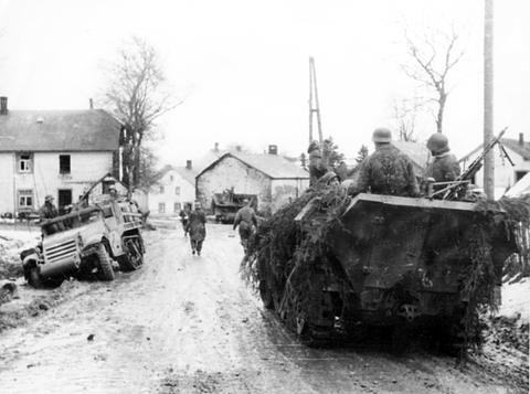Period photograph: German soldiers with two half-tracks on a muddy village road