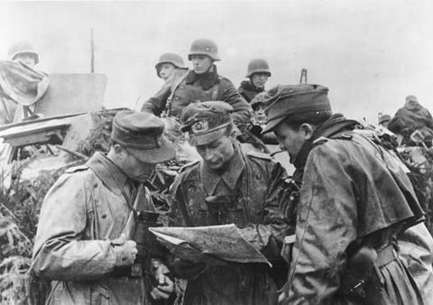 Period photograph: German soldiers in winter clothing studying a map