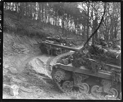 Period photograph: two tank destroyers on a muddy track below a wooded slope