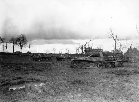 Period photograph: several tanks scattered across a flat, muddy field under a grey sky