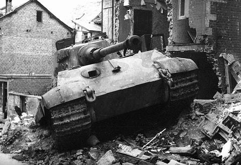 Period photograph: a Tiger II tank among the rubble of a ruined house in a town street