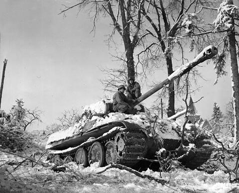 Period photograph: American soldiers on an abandoned Panther tank in a snowy wood
