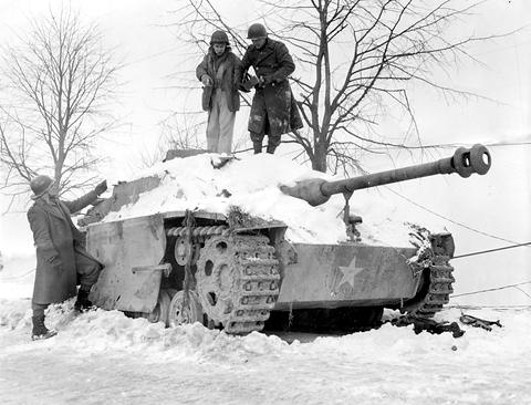 Period photograph: American soldiers standing on a snow-covered StuG III