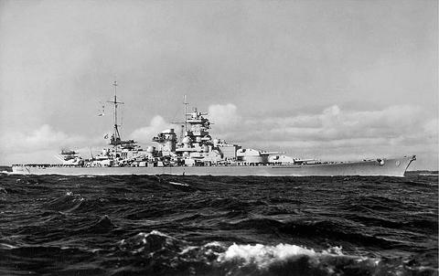 Period photograph: a battleship under way at sea, seen broadside