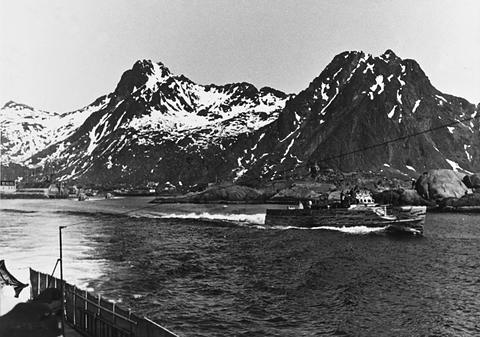 Period photograph: motor torpedo boats under way in a harbour below snow-covered mountains