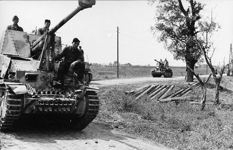 Period photograph: soldiers on an open-topped tank destroyer on a dirt road
