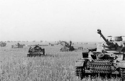 Period photograph: tanks spread across a wide grass plain, one in the foreground