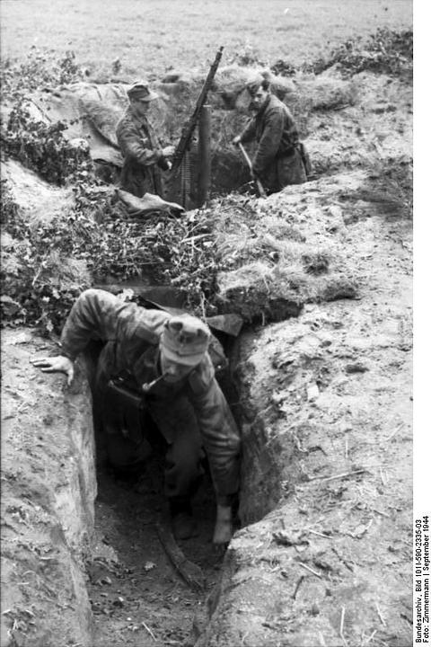 Period photograph: soldiers in a trench, a machine gun mounted on a wooden post
