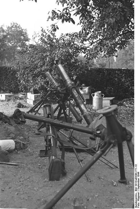 Period photograph: a mortar and its equipment set up in a garden under trees