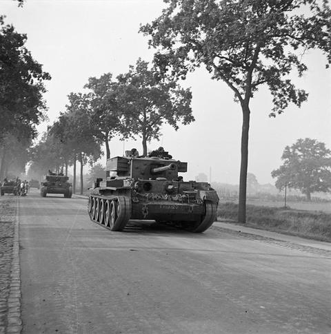 Period photograph: tanks driving along a straight road lined with trees