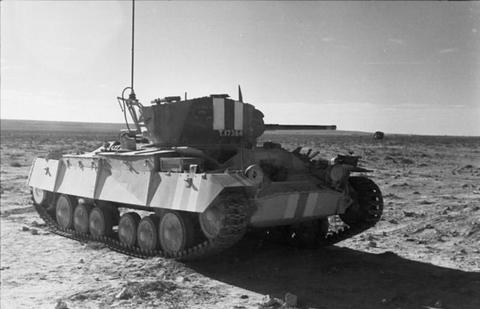 Period photograph: a pale tank with a cross painted on the turret in open desert