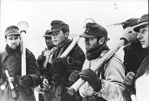 Period photograph: young soldiers in field caps and winter clothing holding Panzerfausts