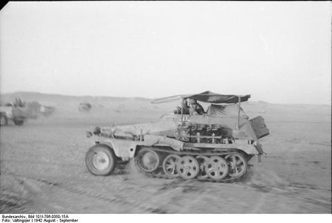 Period photograph: a light half-track with a frame antenna crossing the desert