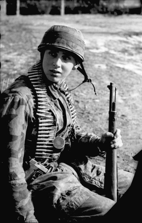 Period photograph: a young paratrooper in a helmet with an ammunition belt round his neck
