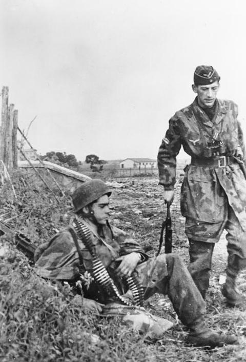 Period photograph: two tired paratroopers in camouflage smocks resting