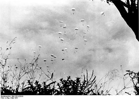 Period photograph: a sky full of parachutes above low vegetation